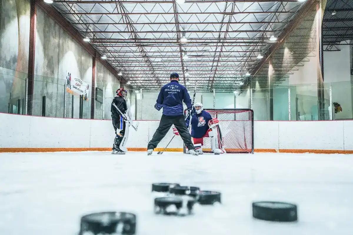 Coach working with hockey goalie during practice